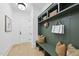 Mudroom with custom green storage and bench seating, complemented by modern décor and hardwood flooring at 3407 Churchill Rd, Raleigh, NC 27607