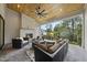 Covered outdoor patio featuring a stone fireplace, comfortable seating, and backyard views at 3407 Churchill Rd, Raleigh, NC 27607