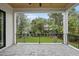 Open-air patio overlooking the back yard with ceiling fan and stone flooring at 3407 Churchill Rd, Raleigh, NC 27607