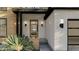 Close-up of the modern wood front door with sidelights and stylish exterior lighting at 3801 Peaceful Creek Trl, Zebulon, NC 27597