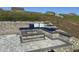 Landscaped backyard featuring a stone patio, a cozy fire pit, and comfortable built-in seating with pillows at 400 Access Dr, Youngsville, NC 27596