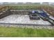 Backyard patio featuring a stylish stone fire pit with built-in seating and lush landscaping at 400 Access Dr, Youngsville, NC 27596