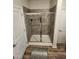 Modern bathroom featuring a tile shower with glass doors and wood-look flooring at 400 Access Dr, Youngsville, NC 27596