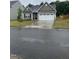 A stylish home features a green lawn, landscaping, a driveway, and a two-car garage, enhancing street appeal at 400 Access Dr, Youngsville, NC 27596
