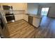 Well-lit kitchen with stainless steel appliances, wood floors, granite countertops, and white cabinets at 400 Access Dr, Youngsville, NC 27596