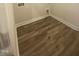 A clean laundry area featuring stylish wood-look floors, washer and dryer hookups, and neutral walls at 400 Access Dr, Youngsville, NC 27596