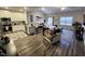 Open-concept living room featuring hardwood floors, modern decor, and an adjacent kitchen with granite countertops at 400 Access Dr, Youngsville, NC 27596
