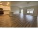 Open-concept living room featuring hardwood floors, modern lighting, and an adjacent kitchen with granite countertops at 400 Access Dr, Youngsville, NC 27596