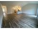 Open-concept living room with hardwood floors and views of the modern kitchen area at 400 Access Dr, Youngsville, NC 27596
