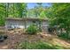 Home's backyard features mature trees, rock landscaping, and a multi-level deck at 4501 Zebulon Rd, Zebulon, NC 27597