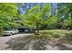 View of the exterior of the home with a covered carport, a well manicured lawn, and mature tree providing shade at 4501 Zebulon Rd, Zebulon, NC 27597