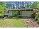 Charming single-story home with a red front door and well-maintained landscaping, nestled among mature trees at 4501 Zebulon Rd, Zebulon, NC 27597