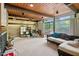 Spacious living room featuring a stone fireplace, wood ceiling, large windows and a comfortable seating area at 4501 Zebulon Rd, Zebulon, NC 27597
