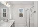Modern bathroom offers a glass enclosed shower, neutral walls, and well-placed windows at 4607 Mint Leaf Ln, Raleigh, NC 27612