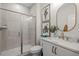 Bright bathroom featuring a glass-enclosed shower, marble countertop, and decorative oval mirror at 4611 Mint Leaf Ln, Raleigh, NC 27612