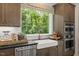 Lovely kitchen with a farmhouse sink, stainless steel dishwasher, and views of the backyard at 4611 Mint Leaf Ln, Raleigh, NC 27612