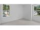Sunlit bedroom with neutral carpet, crisp white walls, and two large windows offering verdant views at 5049 Lundy Dr # 101, Raleigh, NC 27606