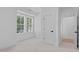 Bright bedroom with neutral carpet, crisp white walls, large window, and adjoining bathroom at 5049 Lundy Dr # 101, Raleigh, NC 27606