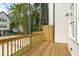 View of the wooden deck with railings surrounded by lush greenery and trees at 5049 Lundy Dr # 101, Raleigh, NC 27606