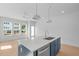 A modern kitchen with a blue island, stainless steel appliances and light hardwood floors at 5049 Lundy Dr # 101, Raleigh, NC 27606