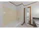 Bathroom featuring a white tiled shower, vanity, and an open doorway at 5109 Knaresborough Rd, Raleigh, NC 27612