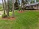 Landscaped front yard featuring trees and green grass in a residential neighborhood at 5109 Knaresborough Rd, Raleigh, NC 27612