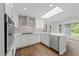 Bright kitchen featuring marble countertops, stainless steel appliances, and a skylight at 5109 Knaresborough Rd, Raleigh, NC 27612
