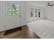 Bright living room with white walls, large windows, ceiling fan, and wood flooring at 5109 Knaresborough Rd, Raleigh, NC 27612