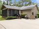 View of the rear exterior featuring a screened-in porch and a well-maintained yard at 5109 Knaresborough Rd, Raleigh, NC 27612