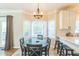 Sunny dining area with a round table, bright lighting, and bar seating adjacent to the kitchen at 540 W Juniper Ave, Wake Forest, NC 27587