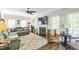 Cozy living room features a fireplace, ceiling fan, hardwood floors, and plush neutral furniture at 540 W Juniper Ave, Wake Forest, NC 27587