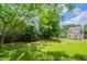 Expansive backyard featuring lush greenery, mature trees, and a wood fence, perfect for outdoor enjoyment at 5522 Marthonna Way, Raleigh, NC 27616