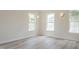 Spacious bedroom with ample natural light, three large windows, and wood-look flooring at 5522 Marthonna Way, Raleigh, NC 27616