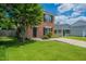 Inviting two-story brick home with lush green lawn, mature tree, and well-maintained landscaping at 5522 Marthonna Way, Raleigh, NC 27616
