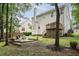 Landscaped backyard with a wooden deck, stone patio and lush greenery at 5629 Yates Garden Ln, Raleigh, NC 27606