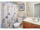 Bathroom featuring a toilet, sink with wooden cabinet, and blue starfish shower curtain at 5629 Yates Garden Ln, Raleigh, NC 27606