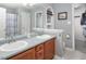 Bathroom featuring double sinks, wooden cabinets, and a framed arched window at 5629 Yates Garden Ln, Raleigh, NC 27606