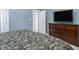 Bedroom features a large bed, gray walls, and a TV atop a wooden dresser at 5629 Yates Garden Ln, Raleigh, NC 27606