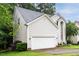 View of the home's vinyl siding, two-car garage, and well-manicured lawn at 5629 Yates Garden Ln, Raleigh, NC 27606