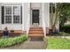 Home's entrance with brick steps and a black front door, complete with fresh landscaping at 5629 Yates Garden Ln, Raleigh, NC 27606
