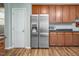 Well-lit kitchen featuring stainless steel refrigerator, granite countertops, and sleek wooden cabinets at 5629 Yates Garden Ln, Raleigh, NC 27606