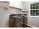 Convenient laundry room with modern washer and dryer, storage cabinets, and bright window at 5629 Yates Garden Ln, Raleigh, NC 27606