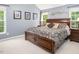 Spacious main bedroom with a large bed, soft carpet, and abundant natural light from multiple windows at 5629 Yates Garden Ln, Raleigh, NC 27606