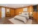 Cozy bedroom featuring brick floors, wood-paneled walls, and a comfortable queen bed at 612 Greenwood Rd, Chapel Hill, NC 27514