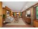 Open living room with exposed brick, wood paneled walls, and lots of light at 612 Greenwood Rd, Chapel Hill, NC 27514