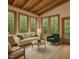 Bright living room with wood ceiling and floor with large windows looking out at the forest at 612 Greenwood Rd, Chapel Hill, NC 27514