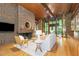 Bright living room boasting a brick fireplace, hardwood floors, wood ceiling, and an abundance of natural light at 612 Greenwood Rd, Chapel Hill, NC 27514
