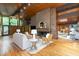 Inviting living room with hardwood floors, brick fireplace, wood ceiling and large windows offering serene views at 612 Greenwood Rd, Chapel Hill, NC 27514