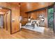 The main bedroom features wood paneling, hardwood floors, a king bed, and a light filled view of the exterior at 612 Greenwood Rd, Chapel Hill, NC 27514