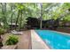 Backyard pool next to wooden deck and wooded home exterior at 612 Greenwood Rd, Chapel Hill, NC 27514
